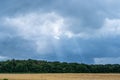 sun rays breaking through storm clouds over rural landscape.. Royalty Free Stock Photo