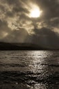 Sun rays breaking through storm clouds in stormy weather over Bala lake in Wales