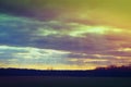 Sun rays through clouds above fields in Iowa before sunset