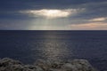Sun rays between clouds over the sea. Royalty Free Stock Photo