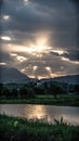 Sun Rays through clouds, sunset above mountains, golden reflection in lake surface water, comfort kindness energy Royalty Free Stock Photo