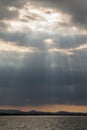 Sun rays coming out through the clouds over a lake Royalty Free Stock Photo