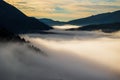 Sun rays falling on mist-clad vegetation and peaks of a mountain range Royalty Free Stock Photo