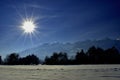 Sun rays over a snow covered field in Schaan in Liechtenstein 16.1.2021 Royalty Free Stock Photo