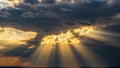 Sun rays breaking through dark clouds in a dramatic sky golden light cloudy Royalty Free Stock Photo