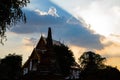 Sun rays shining from behind a big cloud aboce thai temple