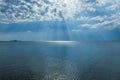 Sun rays shining through the clouds over the sea Royalty Free Stock Photo