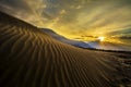 Sun rise at sand dunes against the background of distant colorful mountain range and sunrise sky, Ladakh, Himalaya, Jammu &