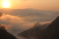 Sun rises over the mist covered mountains of the Bwindi Impenetrable Forest in Uganda