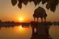 Sun rises on monument silhouettes in Jaisalmer lake