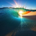At the sun rises over a dazzlingly blue casting its rays of light across the beach in brilliant Royalty Free Stock Photo