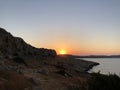 The sun rises and is seen from behind the mountains, on the horizon the coastline of the sea , is planned a sultry clear summer Royalty Free Stock Photo