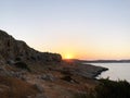 The sun rises and is seen from behind the mountains, on the horizon the coastline of the sea , is planned a sultry clear summer Royalty Free Stock Photo