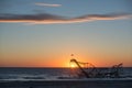Sun rising behind Jet Star Roller Coaster in the ocean