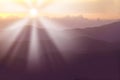 Sun rising behind mountains in summer. Sun rays causing lensflare over the hills in a scenic environment. Forest slopes