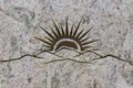 Sun rising behind the mountains, carved into stone surface Royalty Free Stock Photo