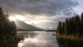 Sun rising on a cloudy sky above mountains and alpine lake , Jasper N.Park, Canada Royalty Free Stock Photo