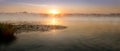 Sunrising over the lake, morning sunrise panorama with fog on the water Royalty Free Stock Photo