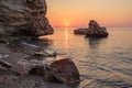 The sun rising over the sea in the early morning rocks and stones in the water a Sunny path Royalty Free Stock Photo