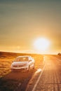 Sun Rising Over VW Volkswagen Polo Vento Sedan Car Parking Near Asphalt Country Road In Sunny Morning Or Evening. Open Royalty Free Stock Photo