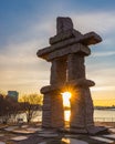 Sun rising in Toronto Canada, seen through an Inuit stone structure, Inuksuk
