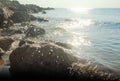 Sun, rocks, reflects and the sea. Royalty Free Stock Photo