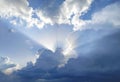 The sun rays behind the cumulus clouds