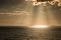 The sun's rays on boats over the island of Elba