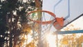 The sun`s rays break through a basketball basket.