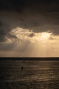 The sun`s rays over the sea, burst out of the cloud. Dramatic sunset on the sea, beautiful peaceful scene, rays of light shine in Royalty Free Stock Photo