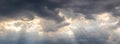 The sun`s rays penetrate through the dark clouds during sunset, panorama Royalty Free Stock Photo