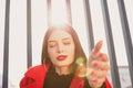 Sun`s rays penetrate grate and shine behind inviting girl, circles from sun in frame Royalty Free Stock Photo