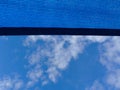 Sun sail. breathing blue fabric sun shade material spanning over terrace area. blue sky and cluds Royalty Free Stock Photo