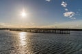 A sun set with star rays. setting over a pier and sea. Royalty Free Stock Photo