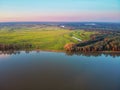 The sun sets behind the river and fills the trees with warm evening light Royalty Free Stock Photo