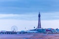 The sun sets on Blackpool beach as people continue to visit during the Covid restrictions. Orange sky and dark blue sea and the