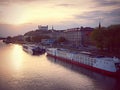 The sun sets over the city of Bratislava, with the Danube river and castle in the background