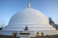 The sun sets over the Maha Seya (stupa) and Buddha statue at Mihintale in Sri Lanka. Royalty Free Stock Photo