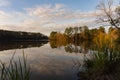 The sun sets over a reflection of clouds and trees in a pond in autumn at historic Yates Mill Country Park in North Carolina Royalty Free Stock Photo