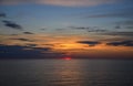Sun is setting behind the Baltic Sea. The sky is colorful combination of yellows, oranges and blues Royalty Free Stock Photo