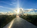 Sun setting behind clouds behind a wooden pier on a lake Royalty Free Stock Photo