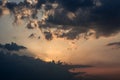 The sun setting behind dark clouds and colorful sky Royalty Free Stock Photo