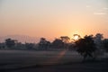 The sun setting behind the mountains of the valley near the field