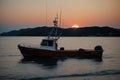 Sun setting behind a quiet fishing boat