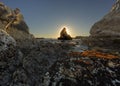 Sun setting behind a sea stack at Shell Beach, La Jolla Cove, California