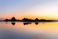 Sun setting beyond horizon on beach