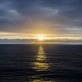 Sun setting on the horizon, reflecting against the surface of the sea