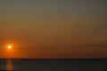 Sun setting over a calm Lake Erie. Well defined light reflection across dark lake.