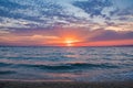 Sun setting over the horizon reflecting the sea with colorful sky above Royalty Free Stock Photo