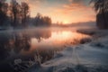 the sun is setting over a lake in the wintertime with snow on the ground and grass in the foreground and trees in the background Royalty Free Stock Photo